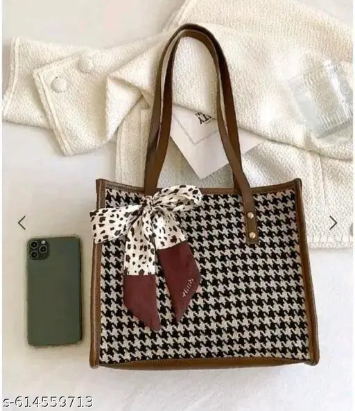Design: Classic houndstooth check pattern with contrasting trims and a decorative bow scarf tied on the front. Material: Premium fabric body with faux leather handles and edges for durability.